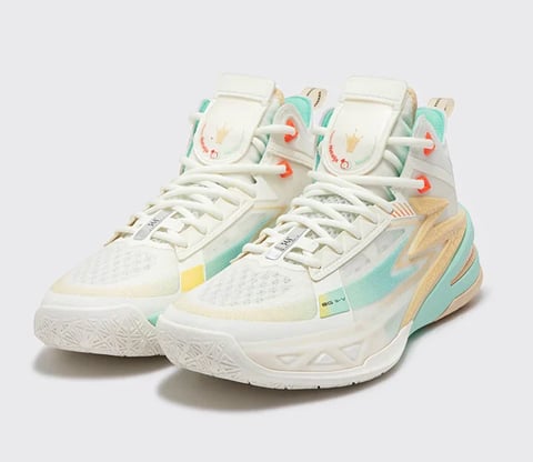 Pair of white high-top basketball sneakers with pastel mint, peach, and yellow accents on a neutral background