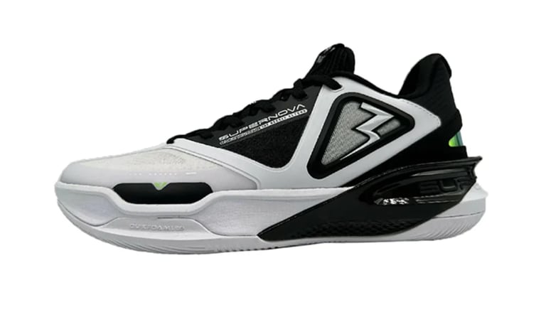 White and black athletic basketball shoe with geometric design and green accent detail on the side